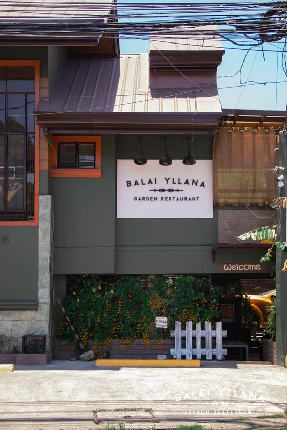 The front of the Balai: green walls, orange window frames and the Balai Yllana Garden Restaurant sign over the entrance, 2021
