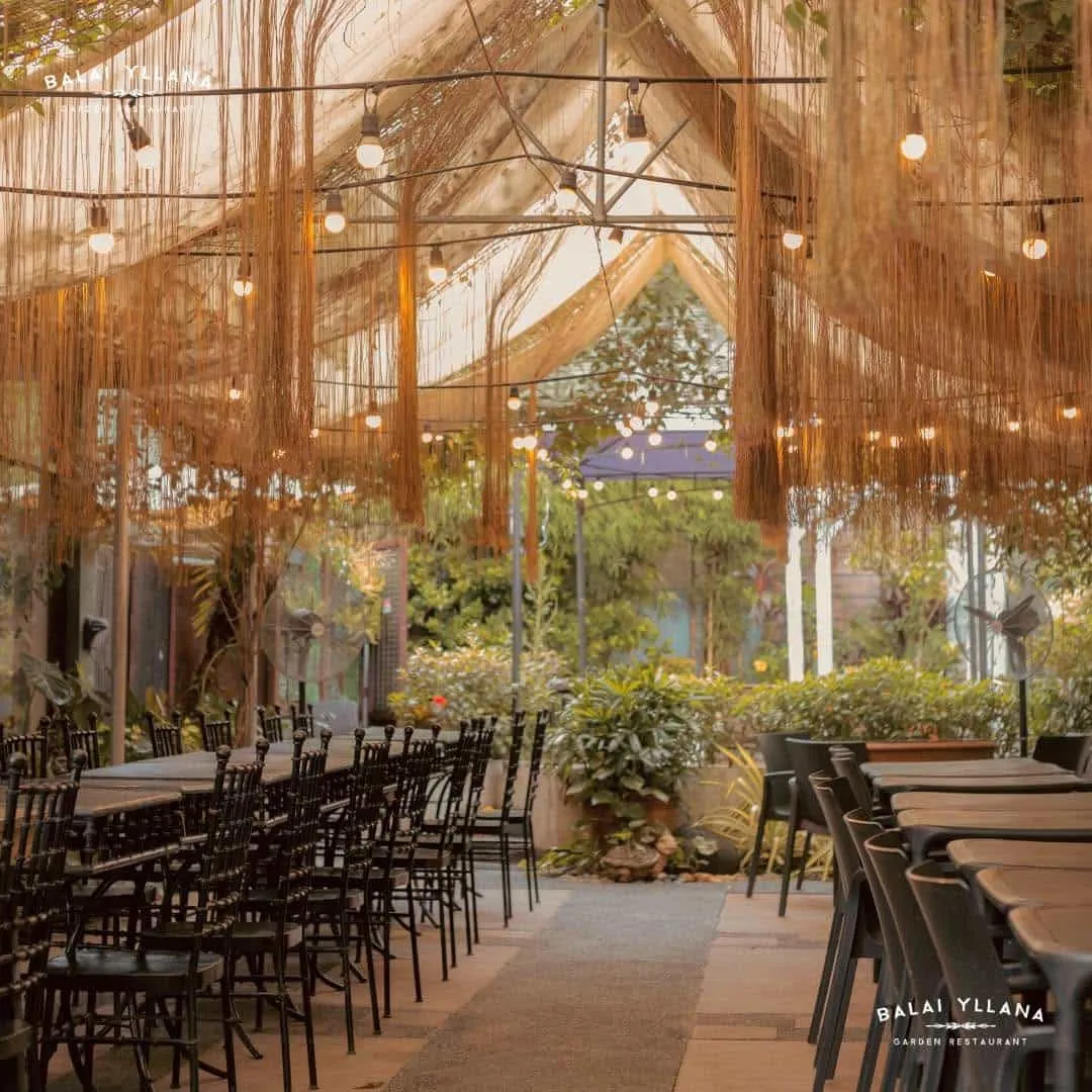 Hanging fringe and string lights over rows of chairs in the garden, 2023
