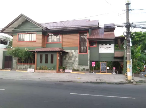 The two-storey house from across the street, with the Balai Yllana Garden Restaurant sign, 2023