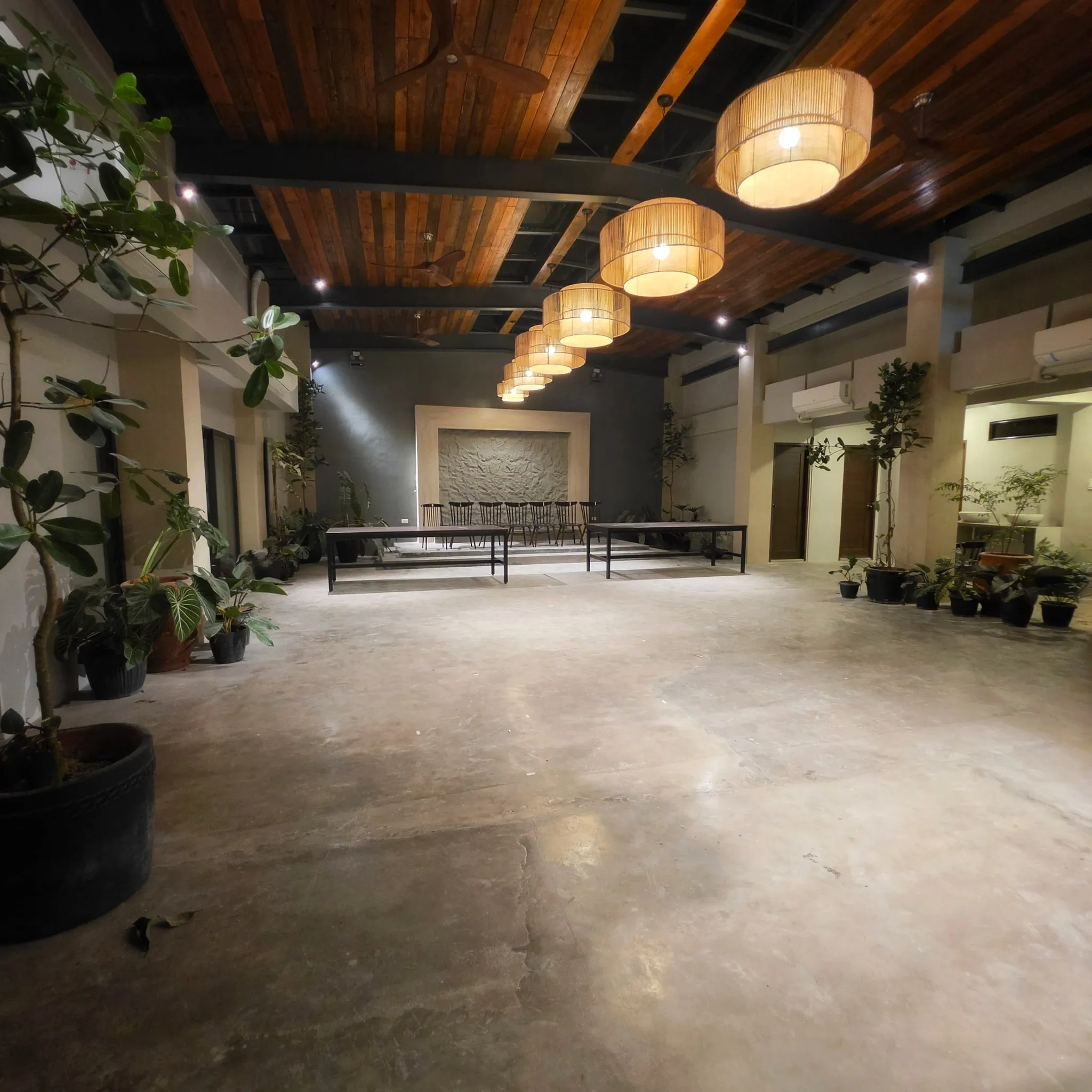 The Lanai: an open hall with woven pendant lamps, potted plants and long tables