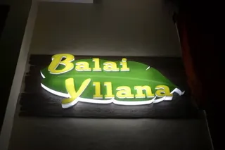 A lit sign with the first Balai Yllana logo: yellow lettering on a green leaf, on a wooden board, 2015