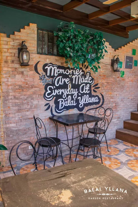A terrace table against a brick wall with a chalkboard sign, 2021
